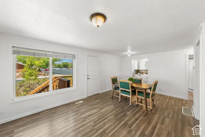 Wood-finish flooring, white walls, and a large window overlooking a wooden deck