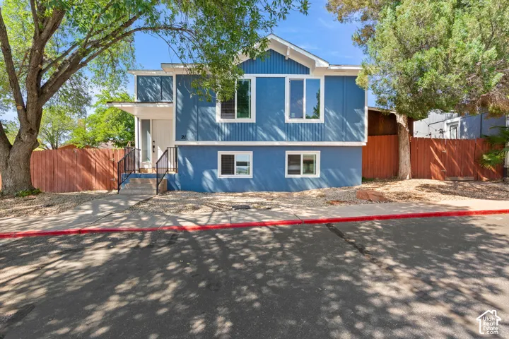 Contemporary facade featuring blue siding, white trim, and a covered entry