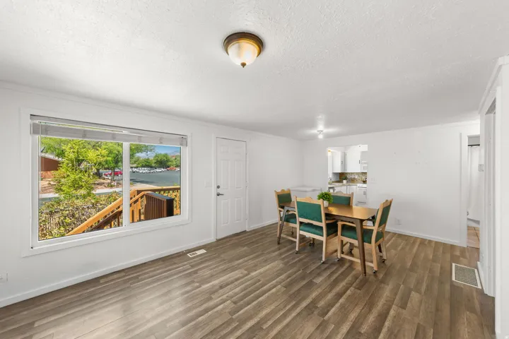Wood-finish flooring, white walls, and a large window overlooking a wooden deck