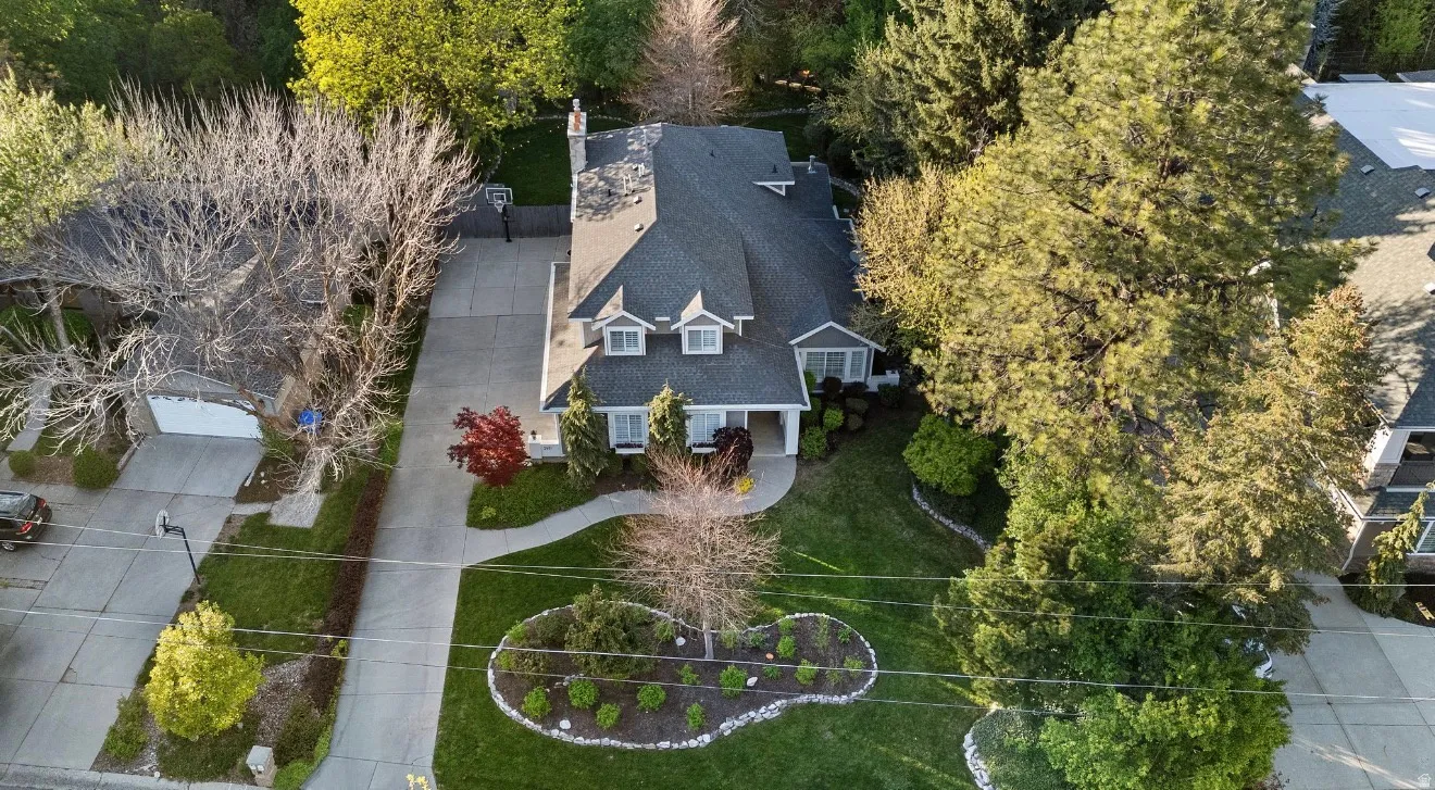 Traditional-style home featuring a gray shingle roof, two front dormer windows, and a covered front porch
