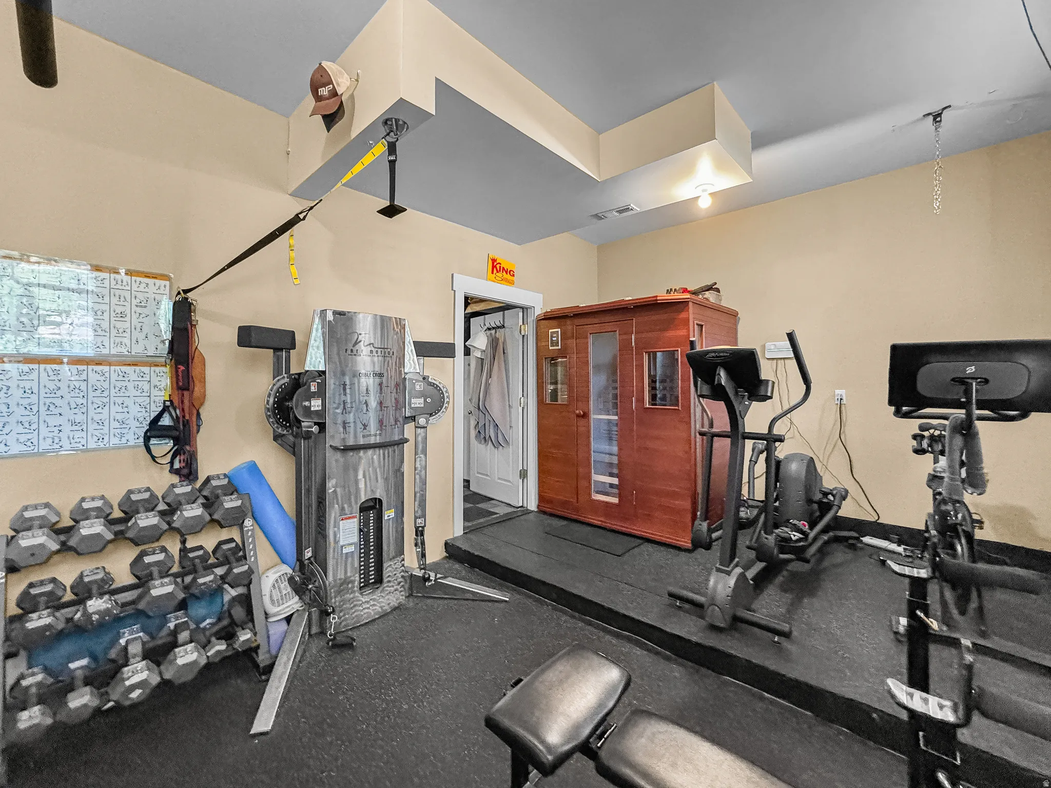 Dedicated fitness space featuring a built-in sauna, durable rubber flooring, and neutral wall paint