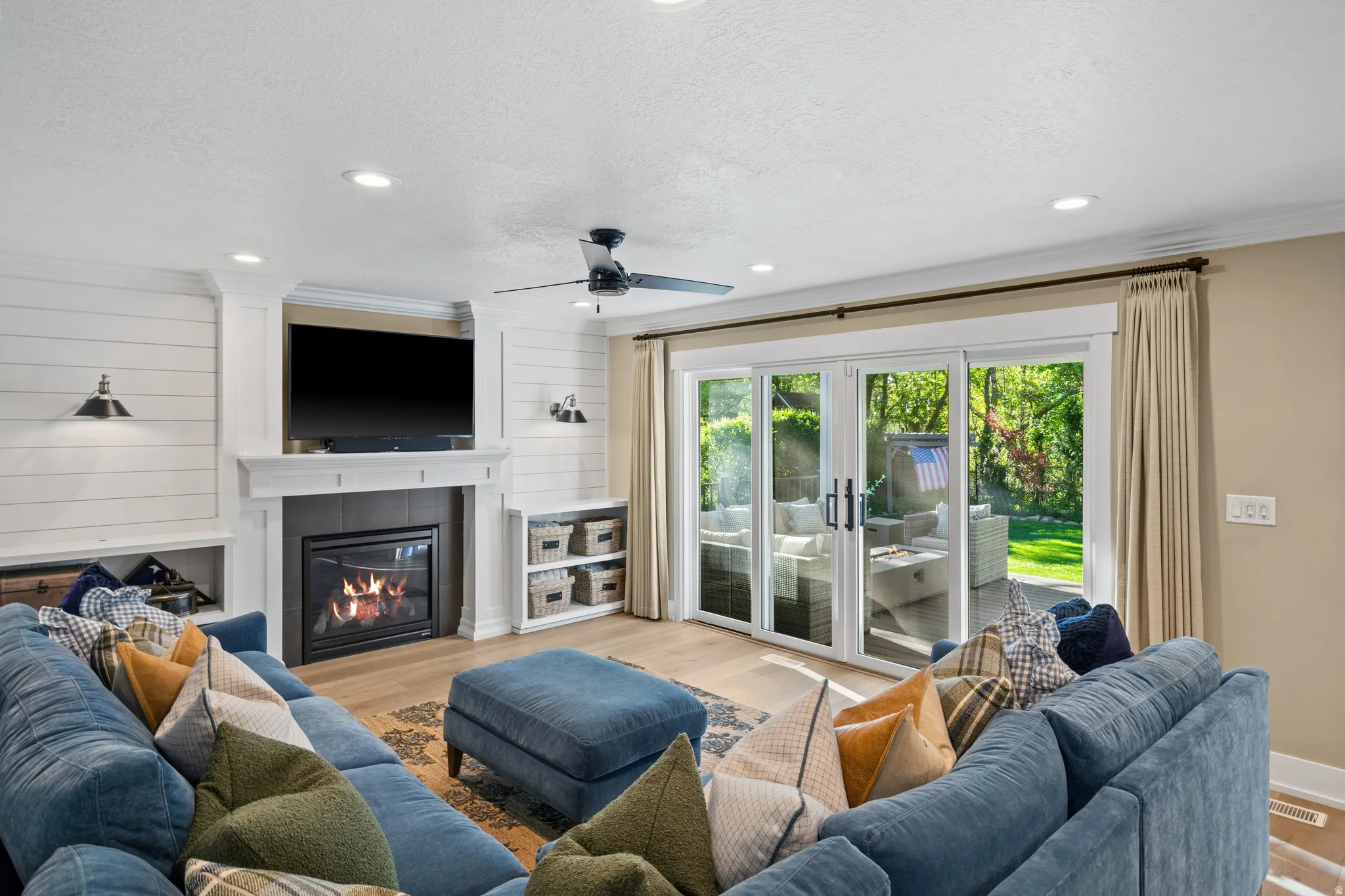 Living area featuring a fireplace with a mantel, built-in shelving, recessed lighting, and wood-finish flooring