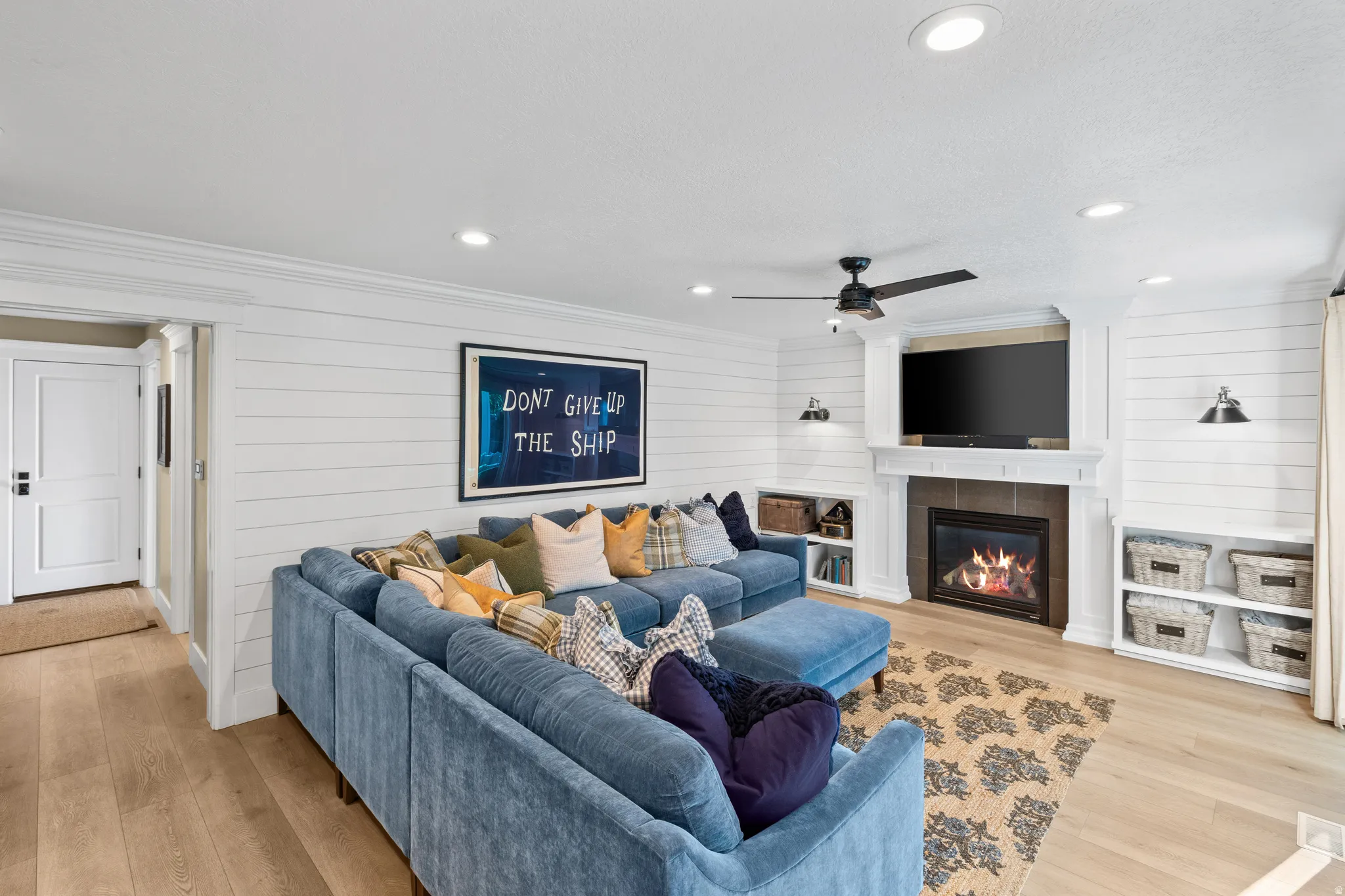 Living area featuring shiplap accent walls and light wood-finish flooring