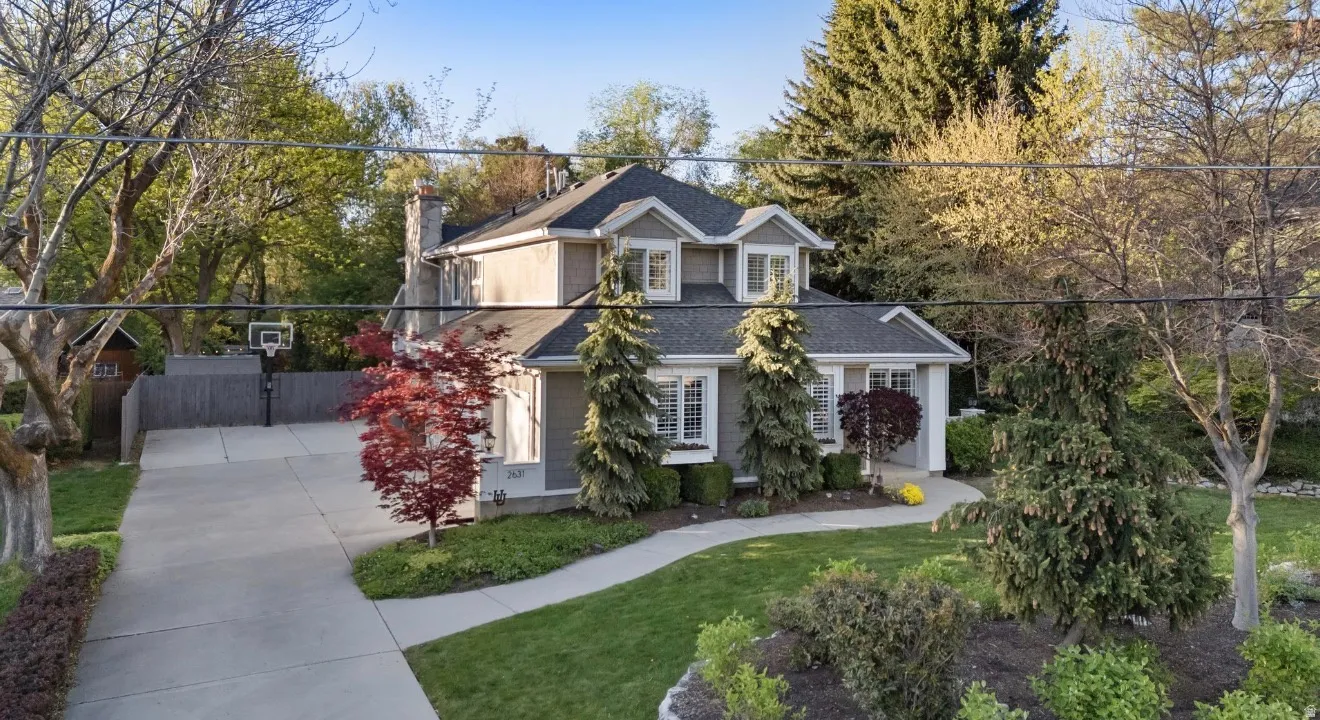 Multi-story residence featuring a gray exterior siding and a dark shingle roof