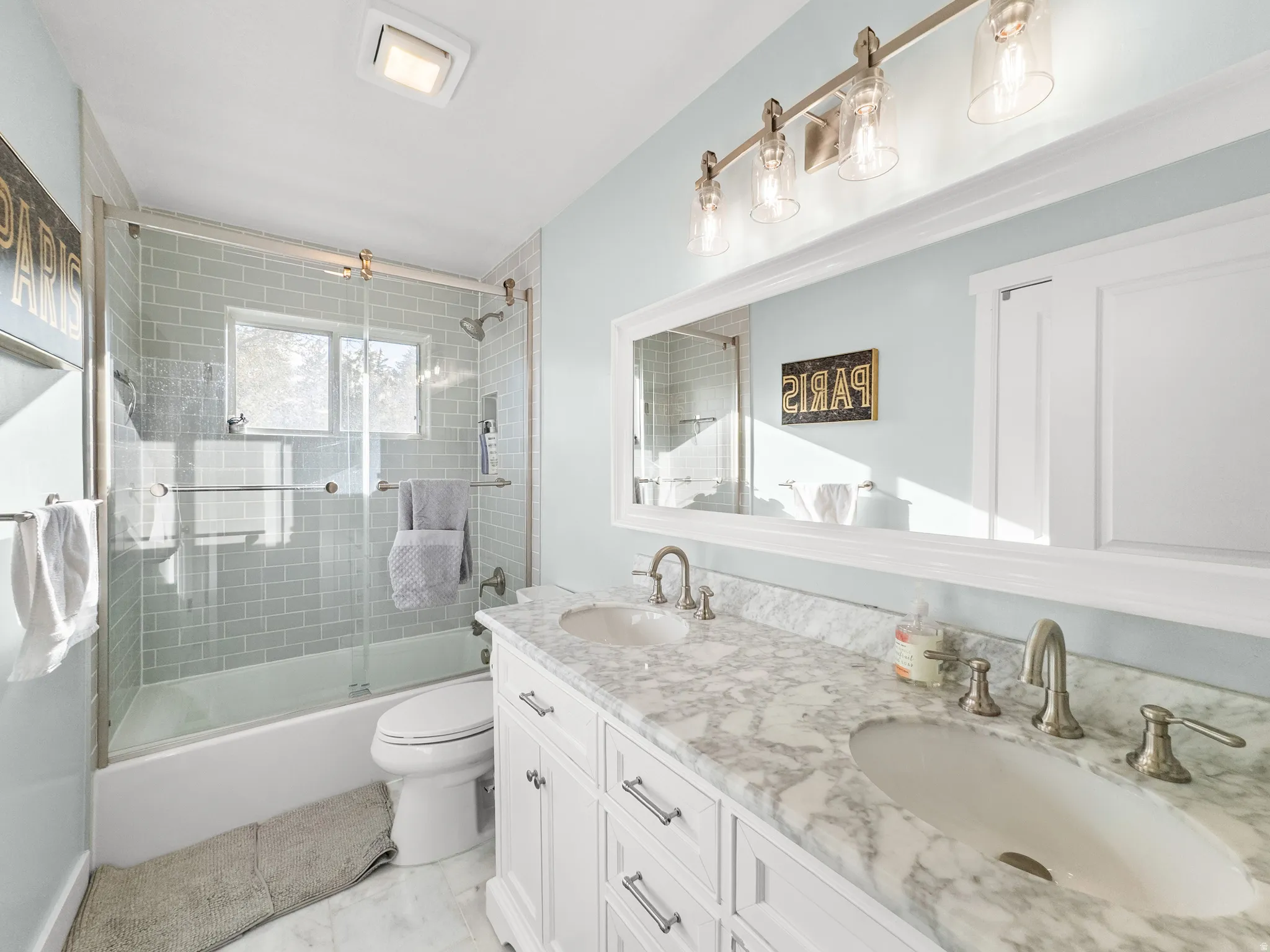 Bathroom featuring a dual vanity with undermount sinks, marble countertop, and brushed nickel fixtures