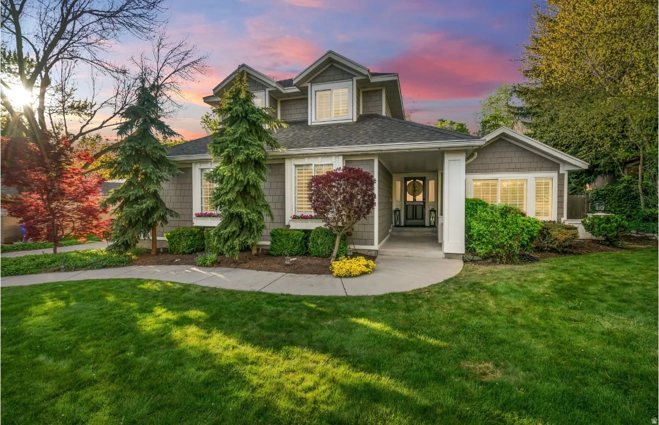 Two-story residence featuring a shingle exterior, a dark gabled roof, and a covered front entry