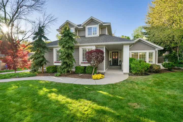 Two-story residence featuring grey shingle siding, white trim, and a dark shingled roof