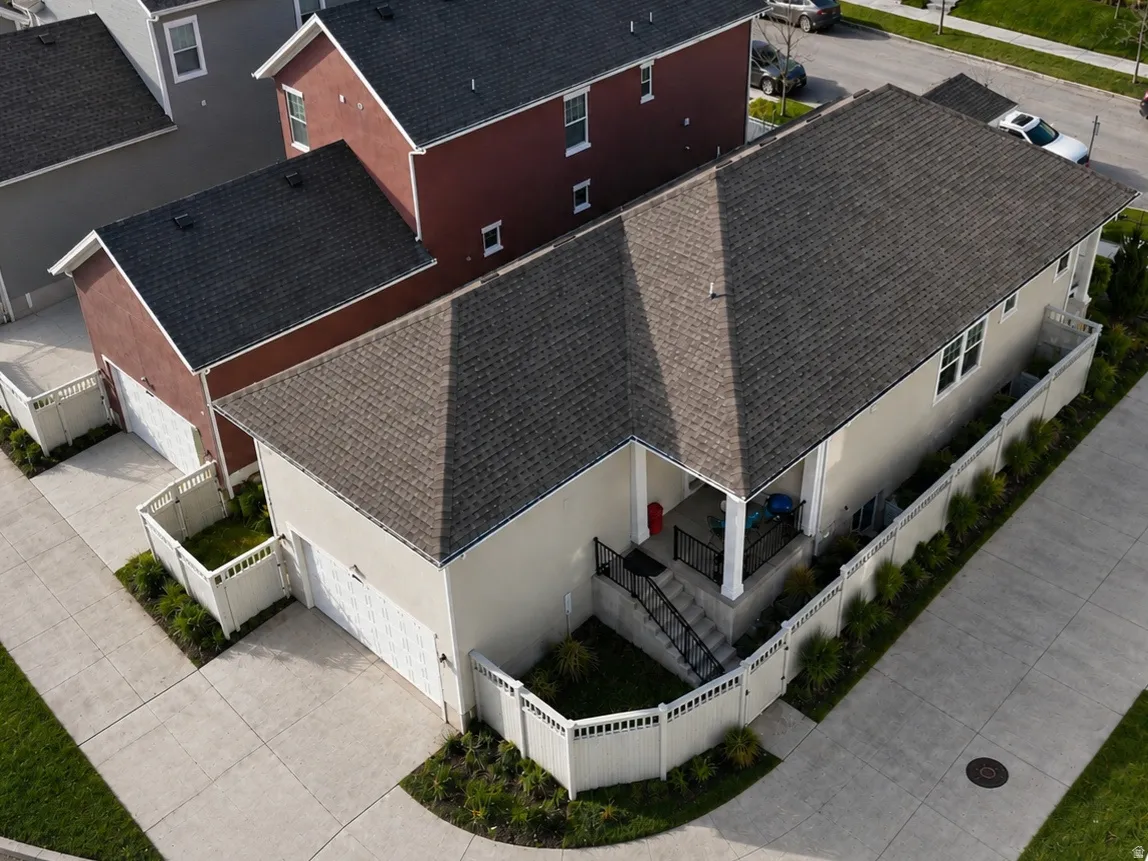 Contemporary residence featuring a two-car garage, and a covered porch with a grassed backyard.