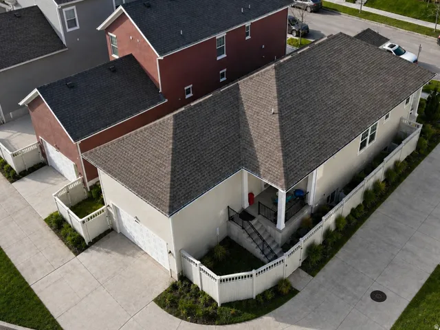 Contemporary residence featuring a two-car garage, and a covered porch with a grassed backyard.