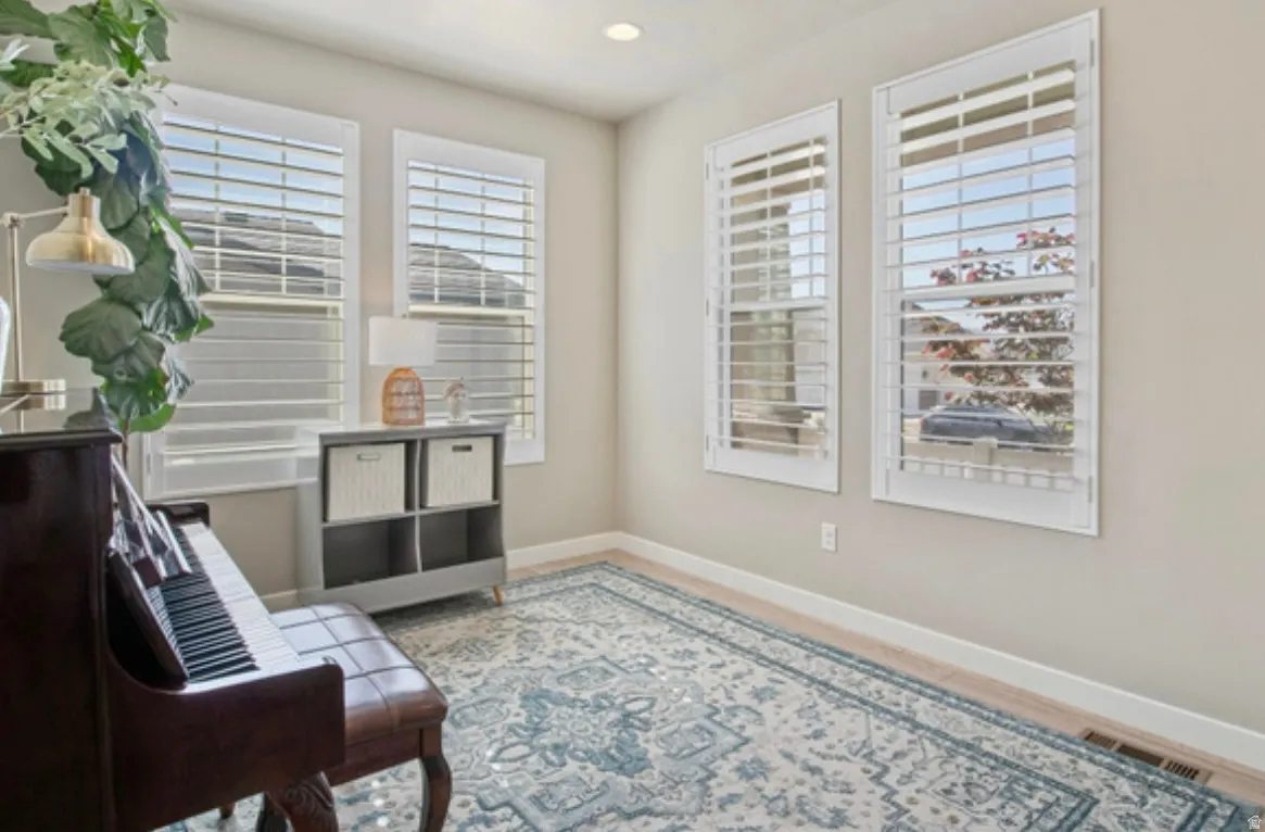 Interior room featuring light-toned walls, recessed lighting, and wood-finish flooring