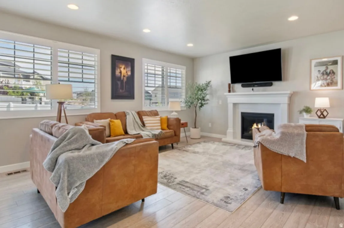 Living area featuring a white fireplace with a dark insert, a mounted television, and recessed ceiling lighting