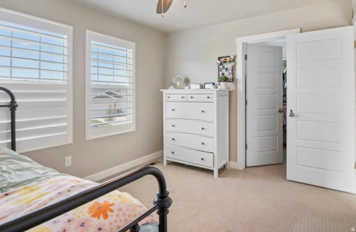 Spacious room featuring neutral paint, two windows with white plantation shutters, and light-colored carpeting