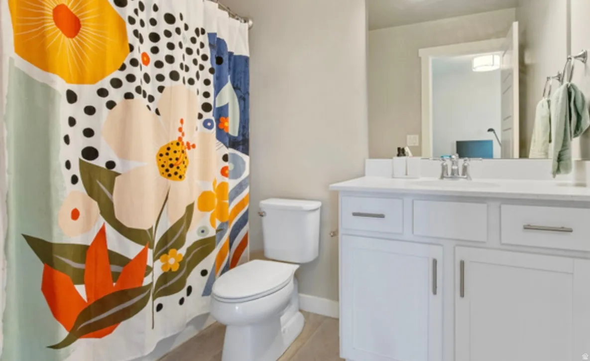 Bathroom featuring a white vanity with integrated sink, chrome faucet, and white cabinetry with brushed nickel hardware