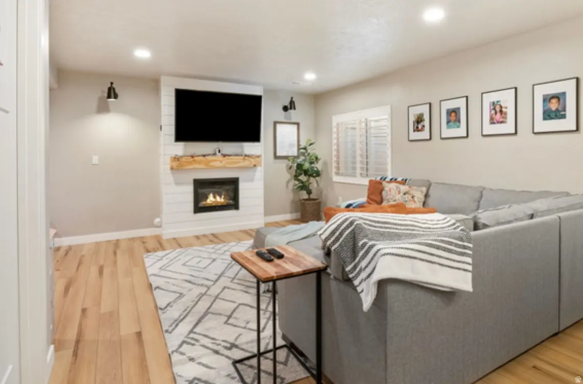 Living area featuring light wood-finish flooring and recessed lighting