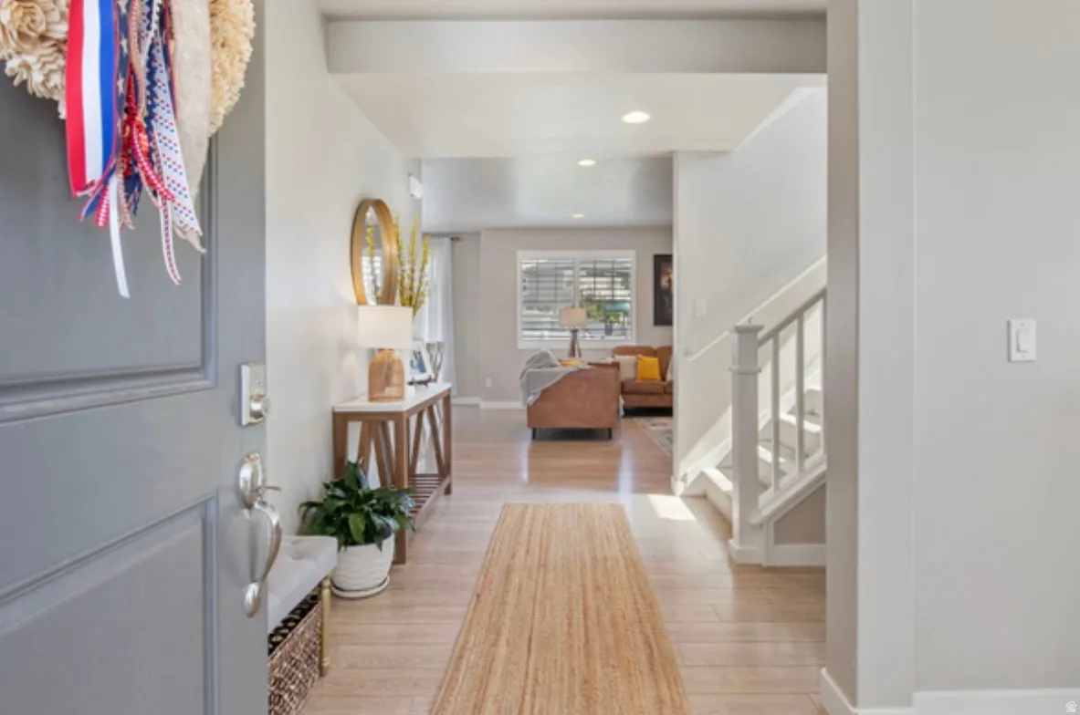 Entryway featuring wood-finish flooring, recessed lighting, and a white staircase with spindle railing