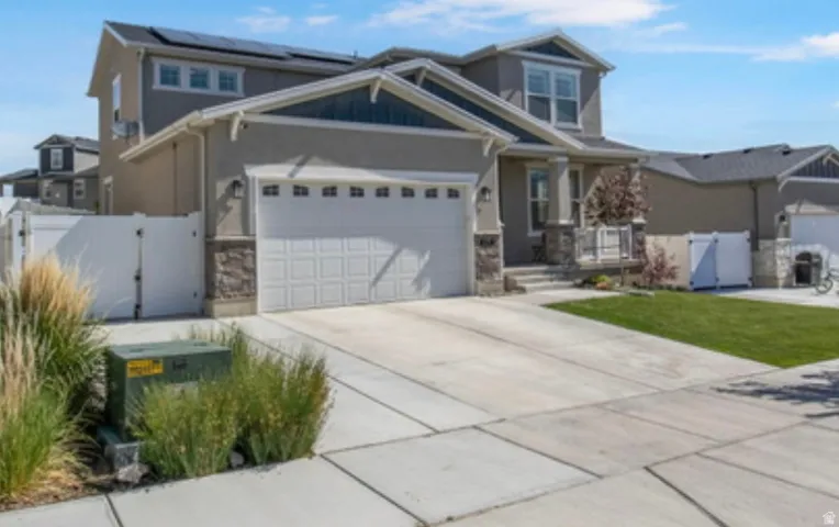 Contemporary two-story residence with a two-car garage, stone façade accents, and an inviting covered porch entry