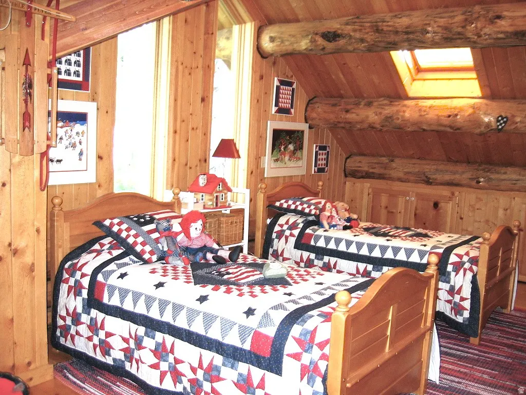 The loft bedroom showing twin/bunk beds, Velux opening window  with screen and deep storage cabinets along the East wall.