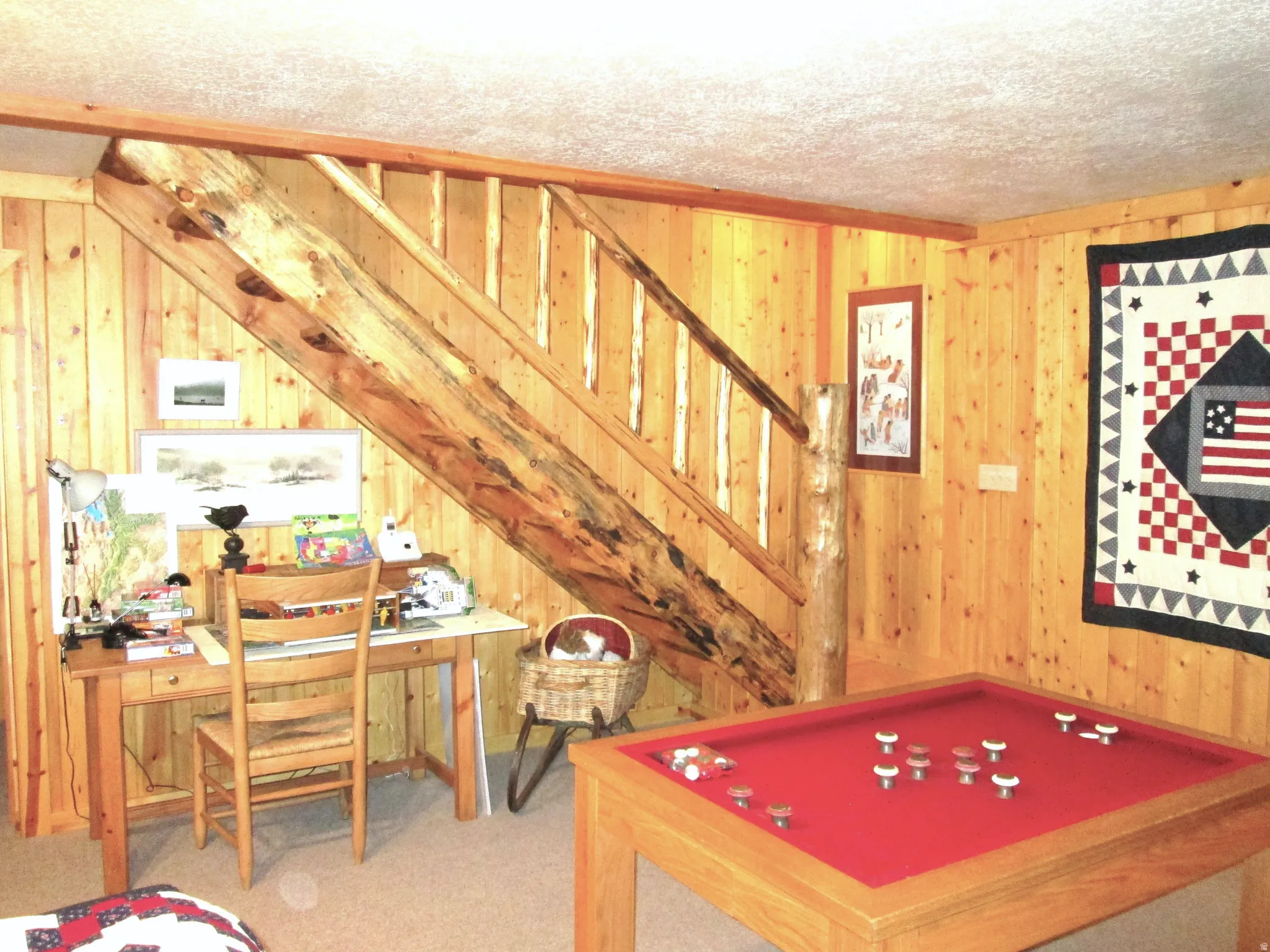 The staircase to the lower level family room with a fly-tying or puzzle building area.