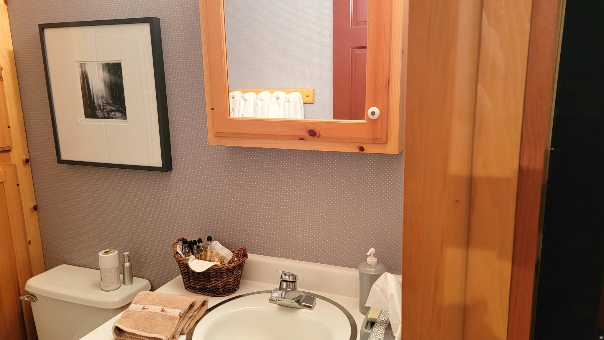 There is a pine vanity and matching custom mirrored medicine cabinet.