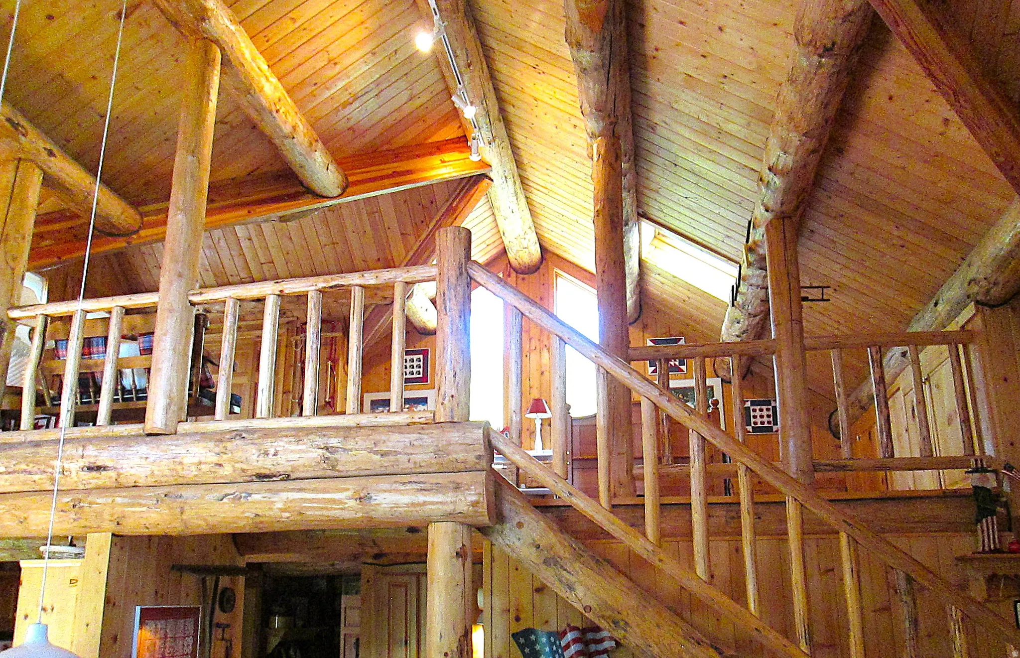 Detailed view of the vaulted loft ceiling with exposed beams, and a second story overlook to the great room.