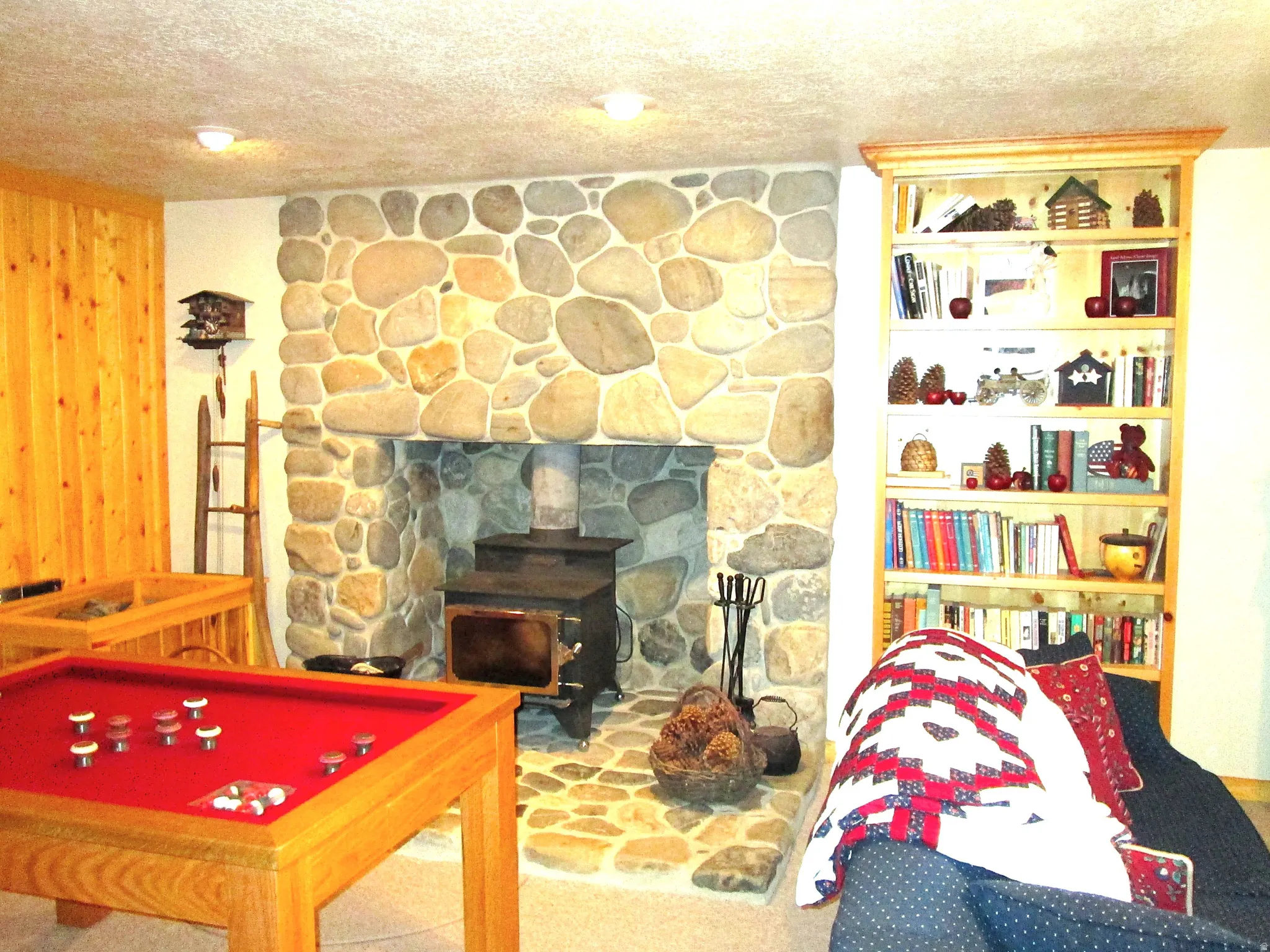 A wood burning stove heats the whole cabin in the winter and has a gray river rock hearth and pedestal.