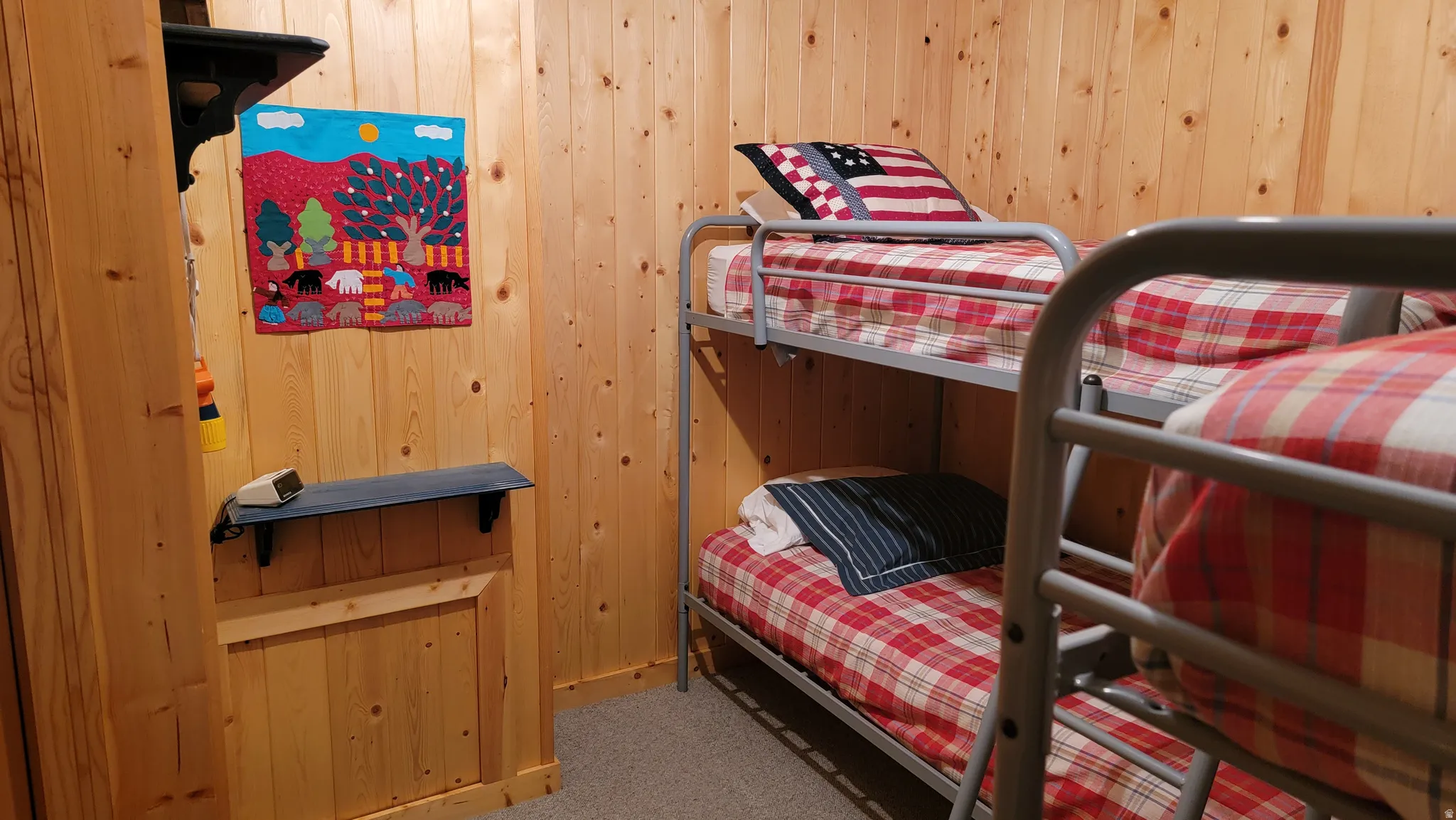 The bunk room  has shelving on two walls.