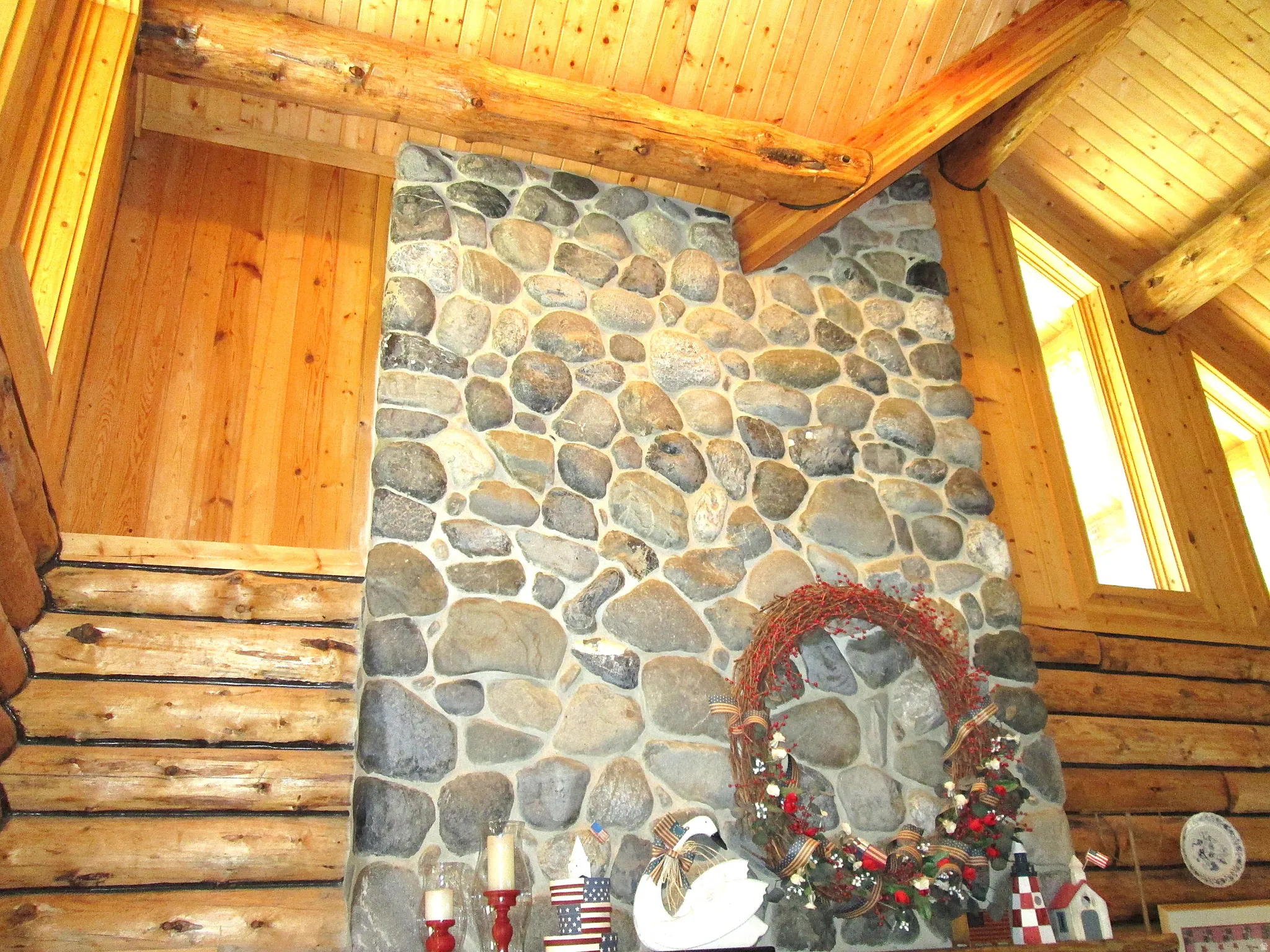 View of the upper great room showing the top of the river rock fireplace and the clerestory windows.