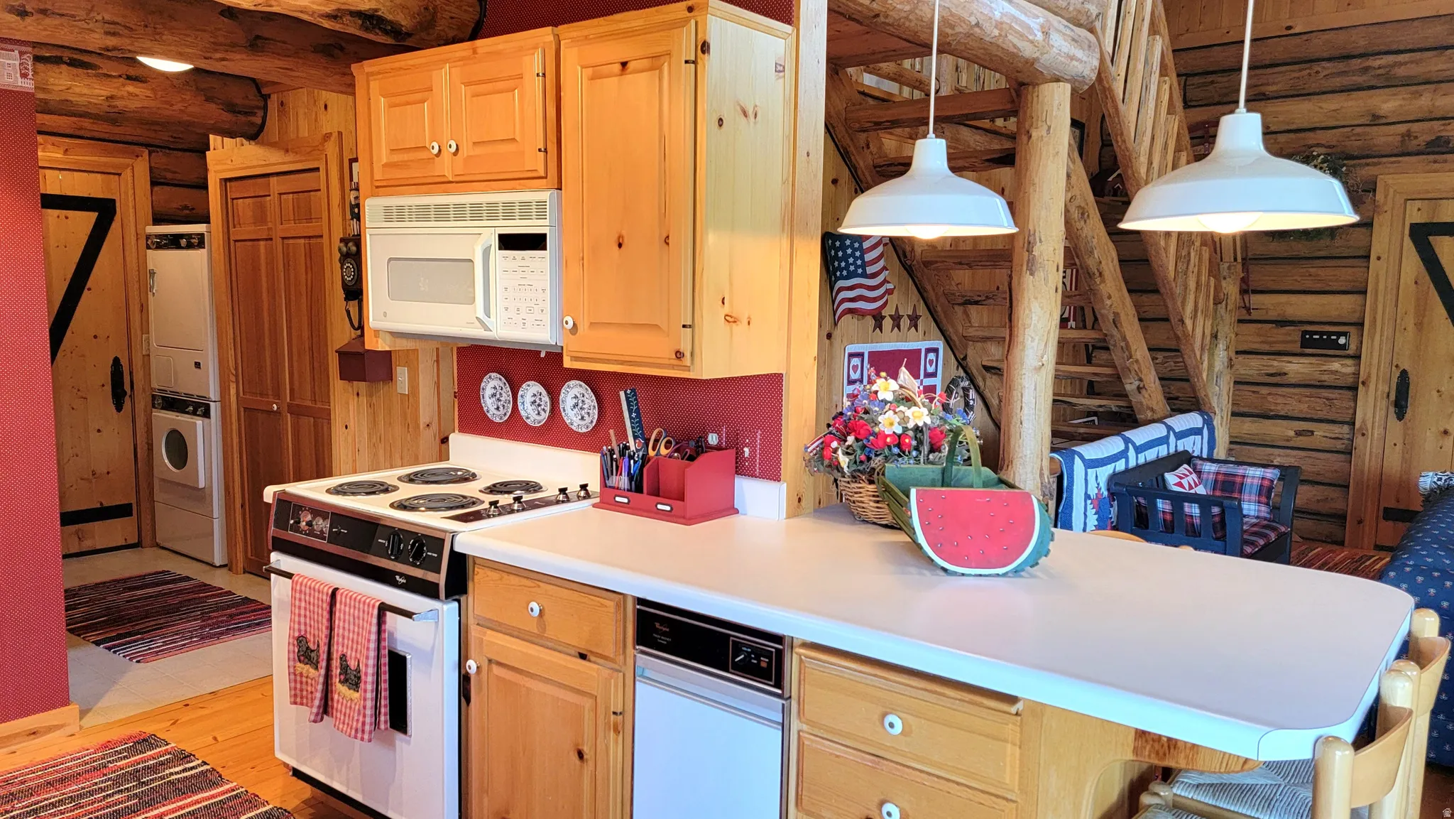 Kitchen view 4: The island, with trash compactor, microwave, range and pendant factory lighting.