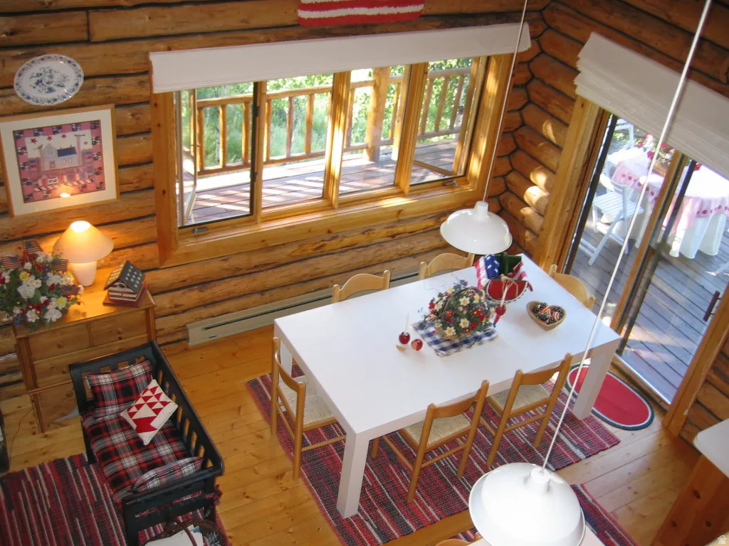 The dining area has an extendable custom built table, suspended factory lighting fixture and view windows. The sliding door opens to the deck.