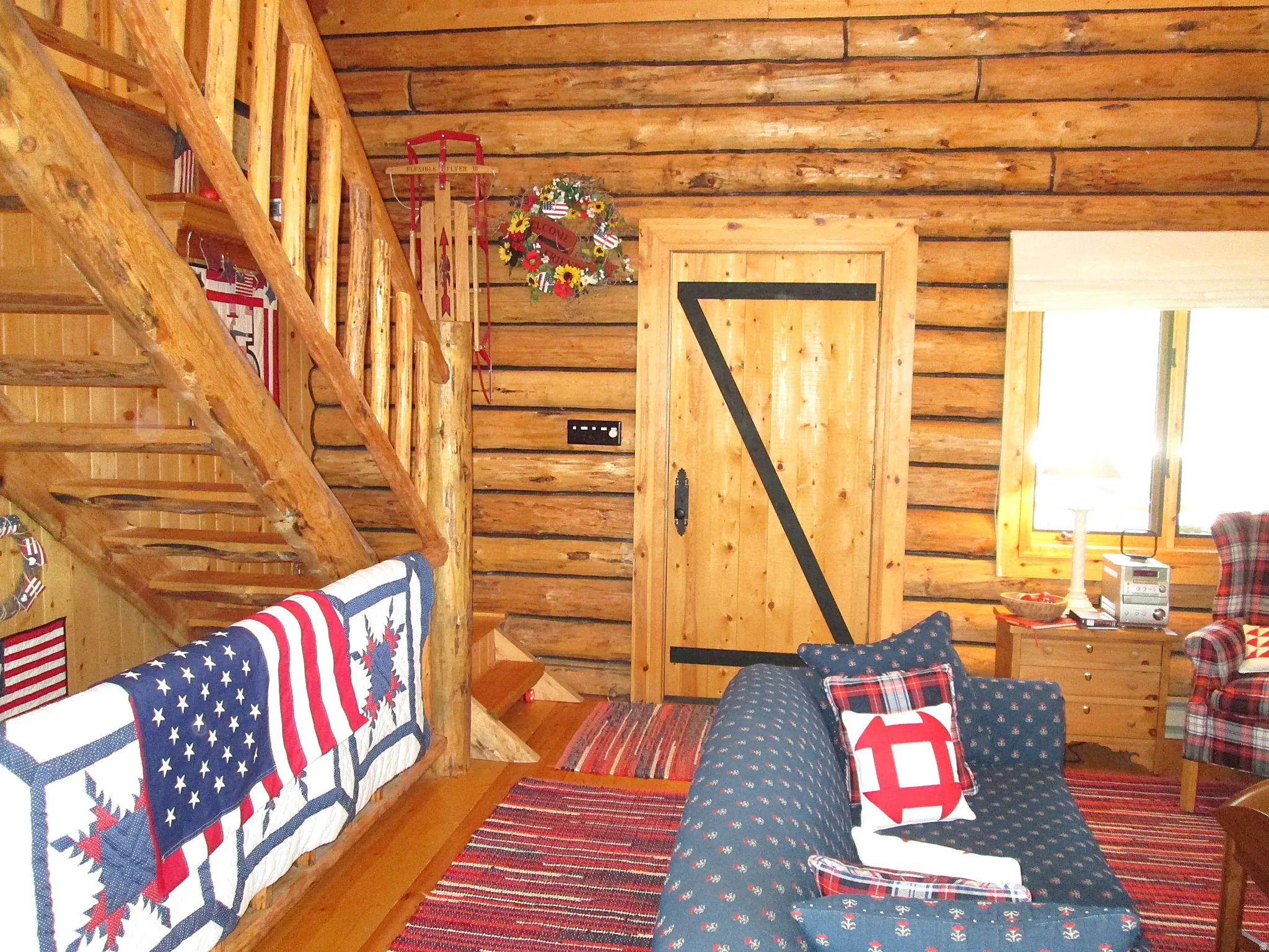 Inside the front door is the great room and log stairway to the loft bedroom.
