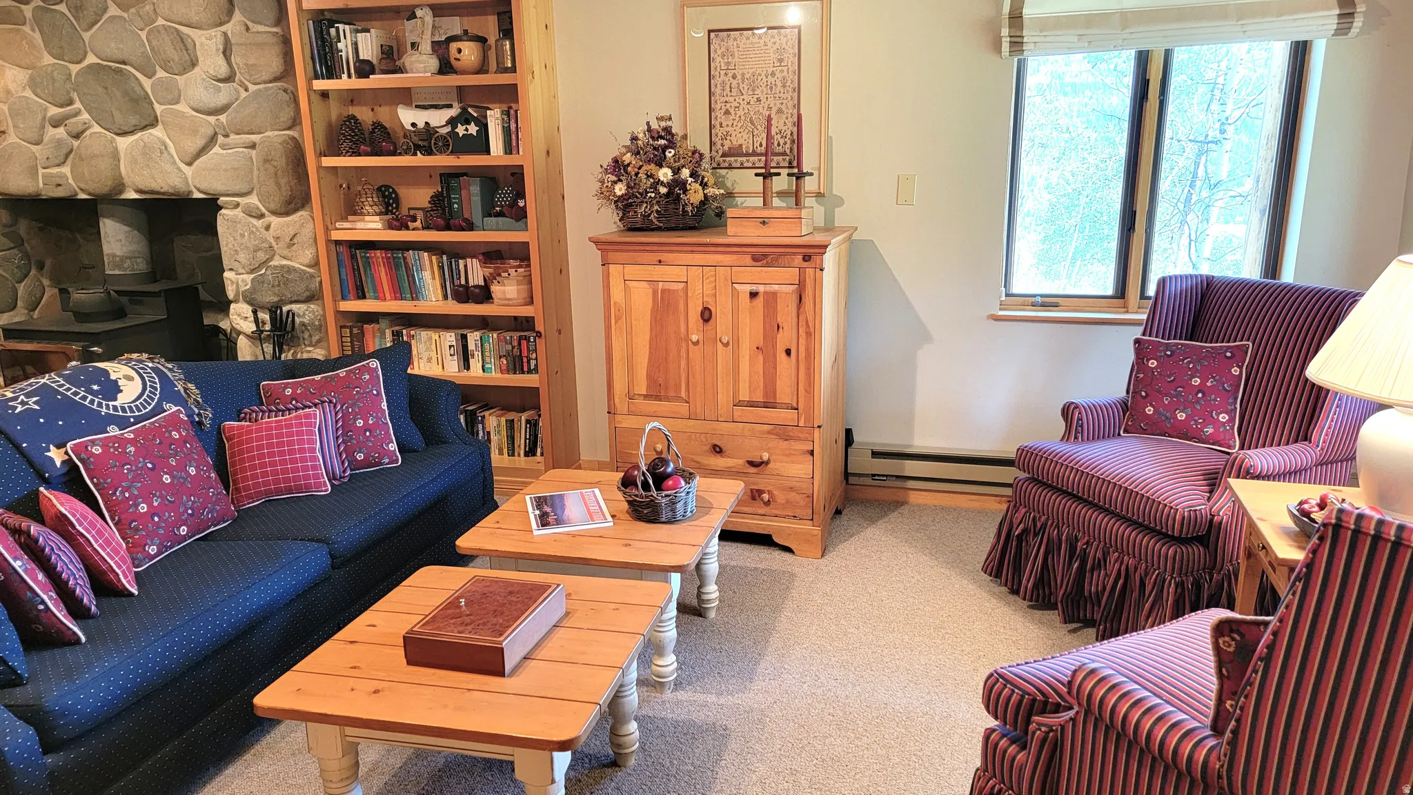 Seating area with a media cabinet, roman shades, a built in bookcase and wool Berber carpet.