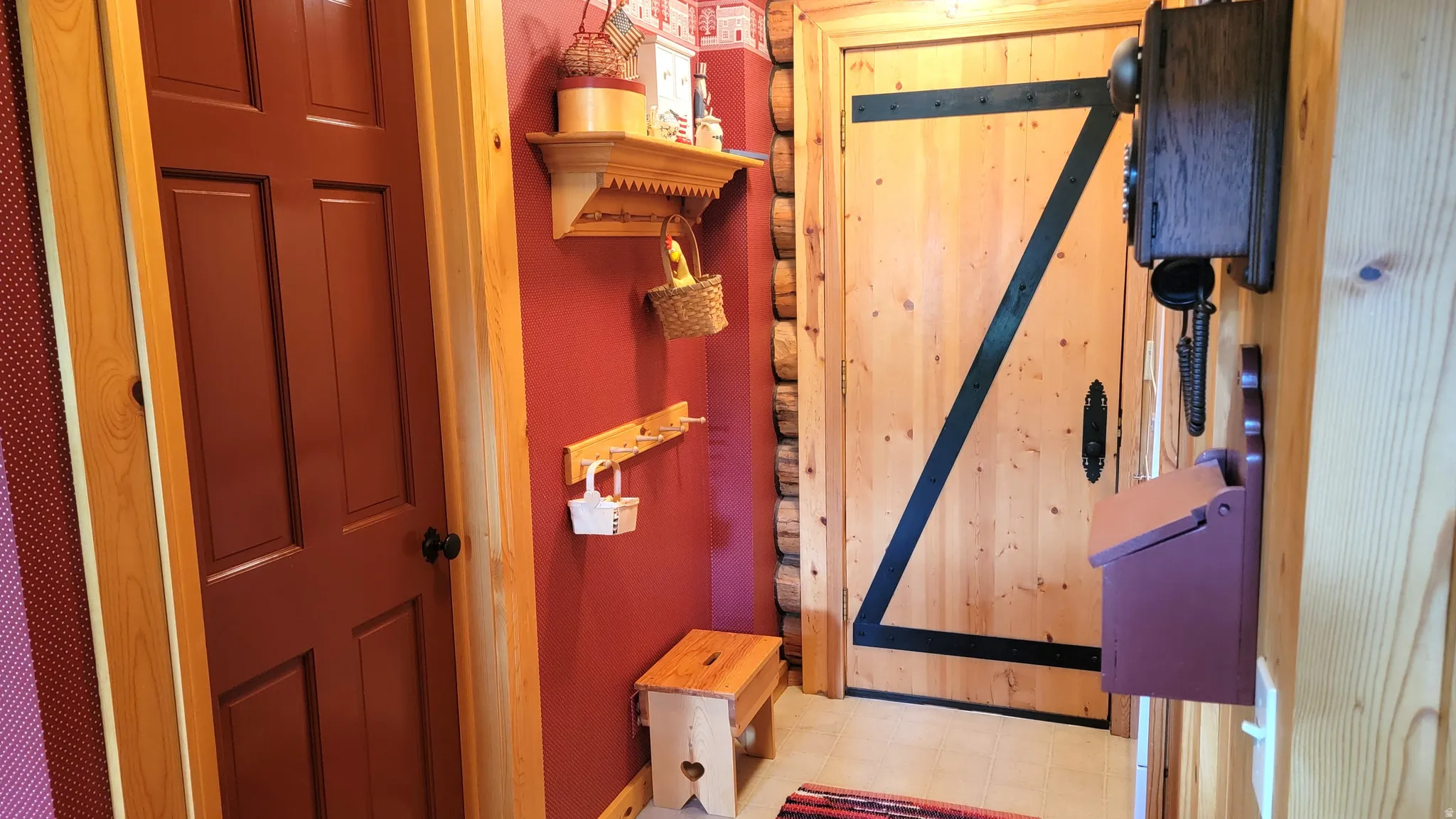 Coat racks, ornamental shelf & door to the full bath.