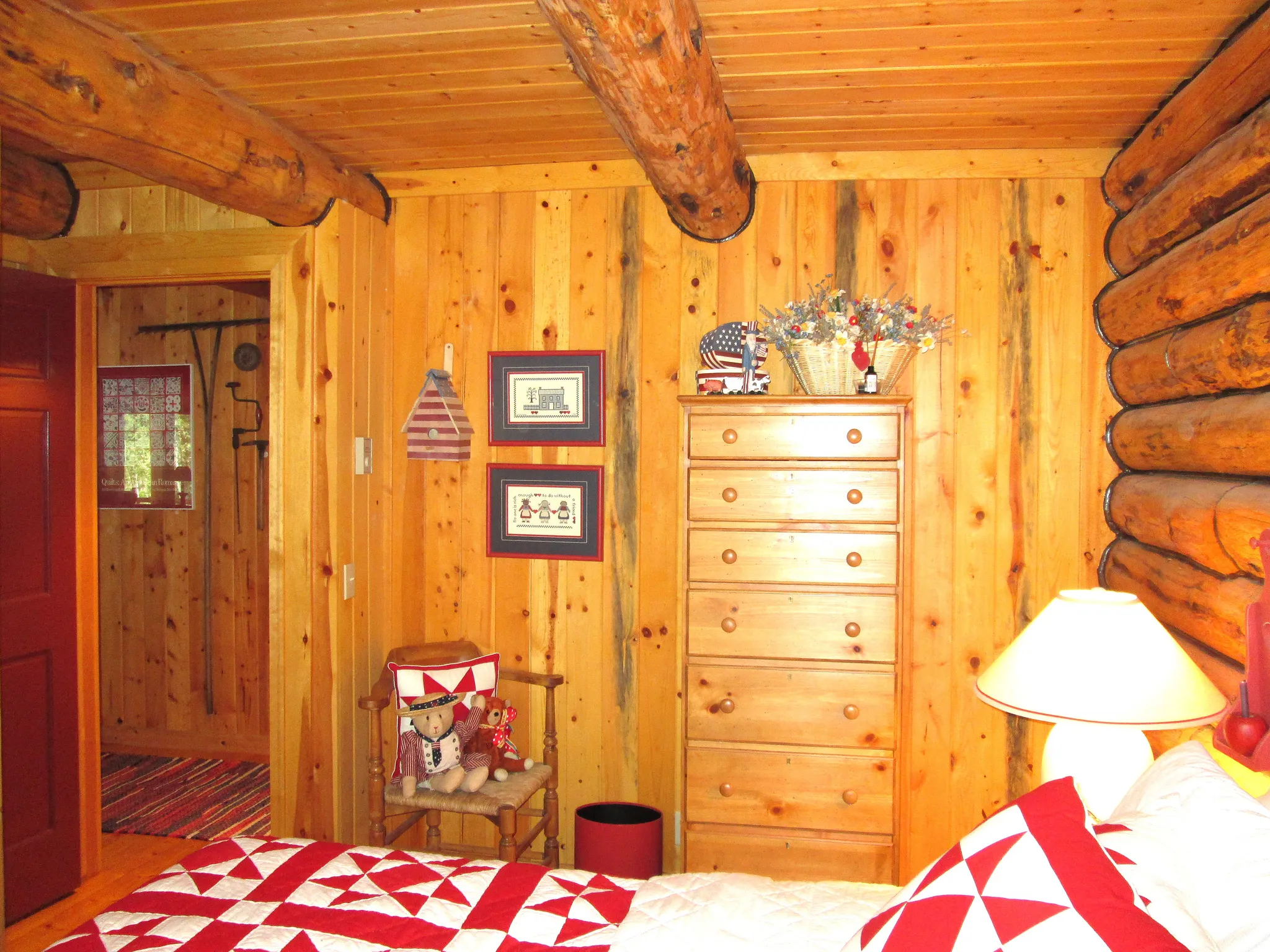 The primary bedroom has log exterior walls and pine paneling interior walls. Most of the furniture in the cabin is from the beautiful Lane, Americana Collection.