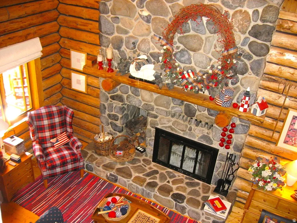 A two-story fireplace made of gray river rock from American Fork Canyon, has a log niche, a raised hearth, and a log mantle. There is an electric blower to warm the main floor.