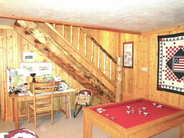 The staircase to the lower level family room with a fly-tying or puzzle building area.