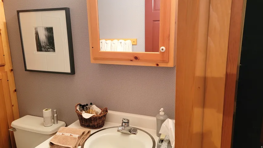 There is a pine vanity and matching custom mirrored medicine cabinet.