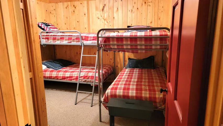 The lower level bunk room with 2 sets of twin beds. Bunk room has no window. There are 2 outside exit doors close by in the family room and the utility room.