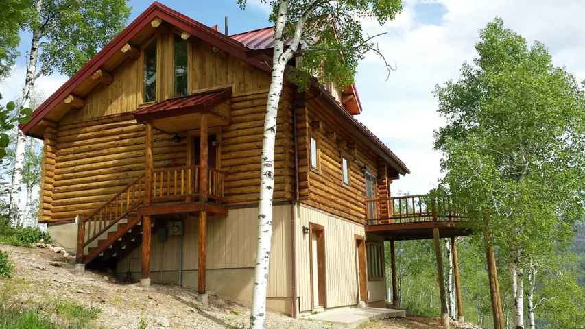 The east and west side of the cabin, showing the back deck and doors to the family room and utility room.