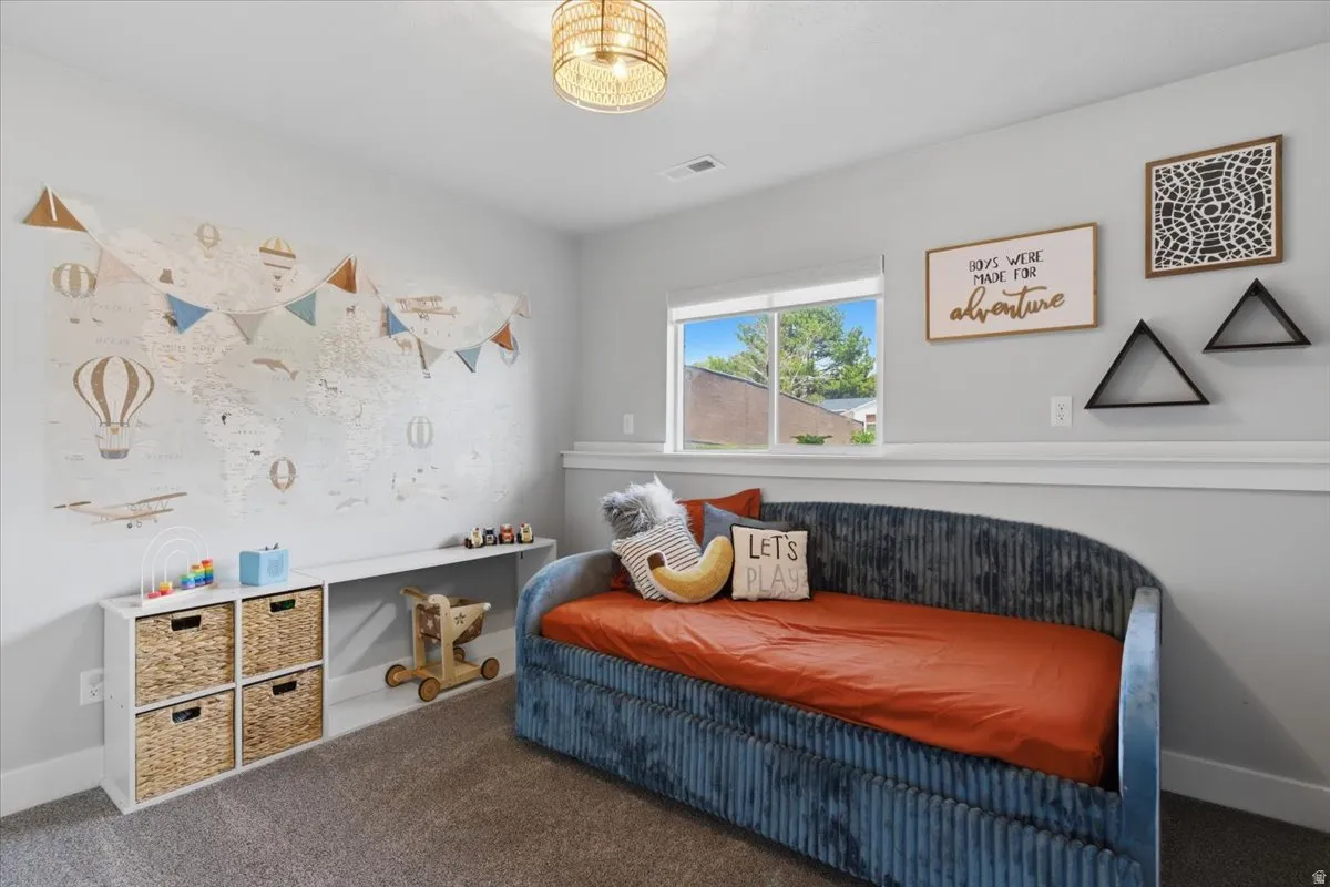 Bedroom featuring a built-in wall shelf and a woven light fixture