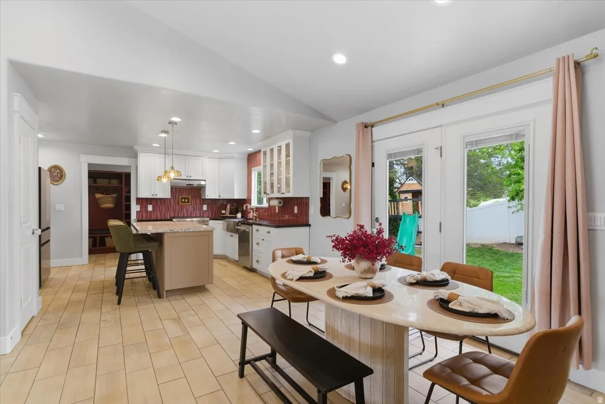Open-concept kitchen and dining area featuring light tiled flooring and white cabinetry