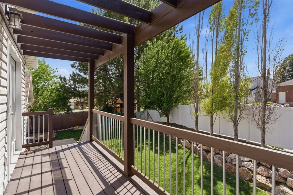 Spacious pergola deck with dark wood-finish and railing, featuring trex decking
