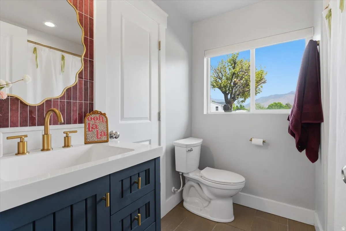 Jack and Jill bathroom featuring a dark blue vanity and gold-tone hardware