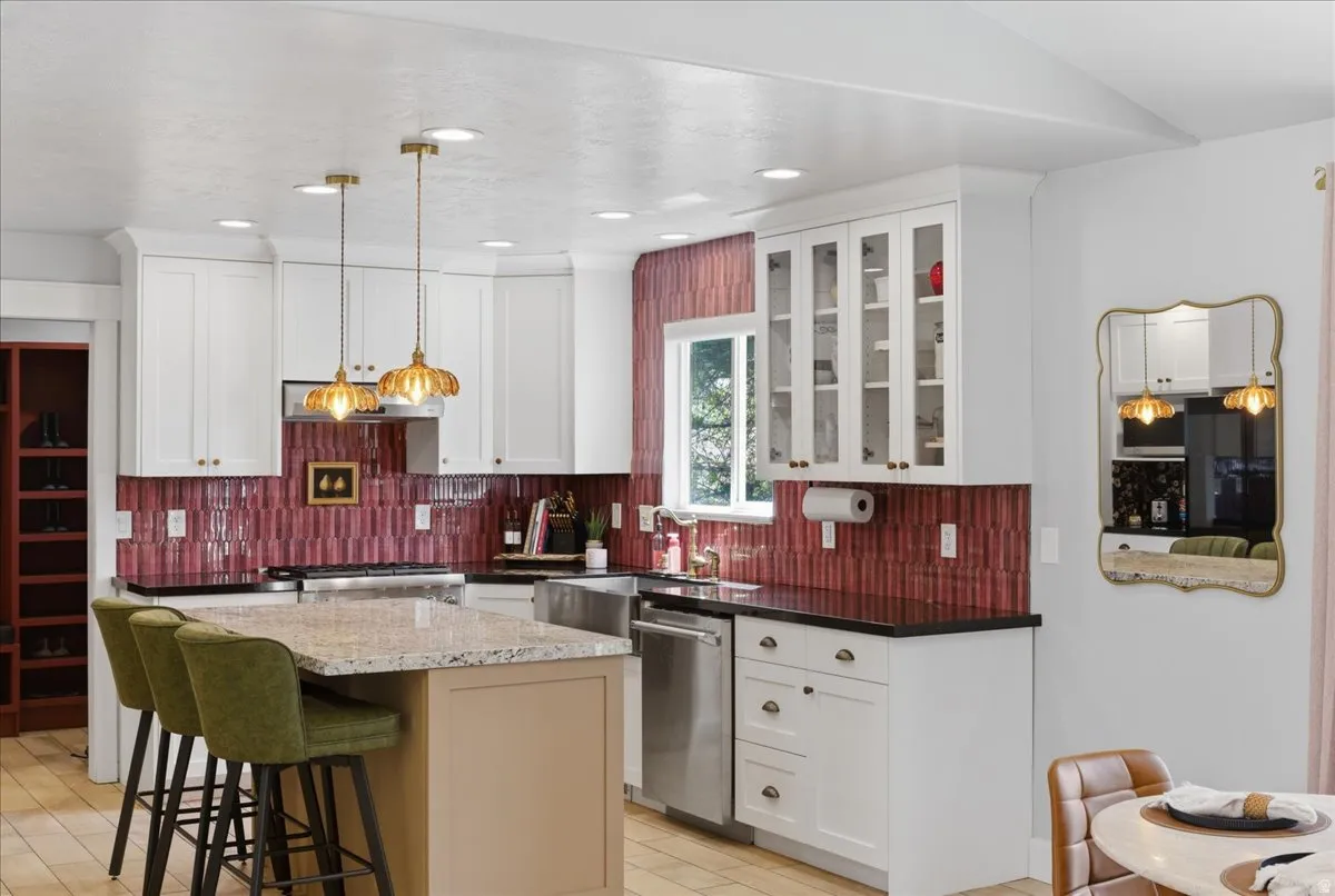 Kitchen featuring white cabinetry, granite countertops, stainless steel appliances, and a large island