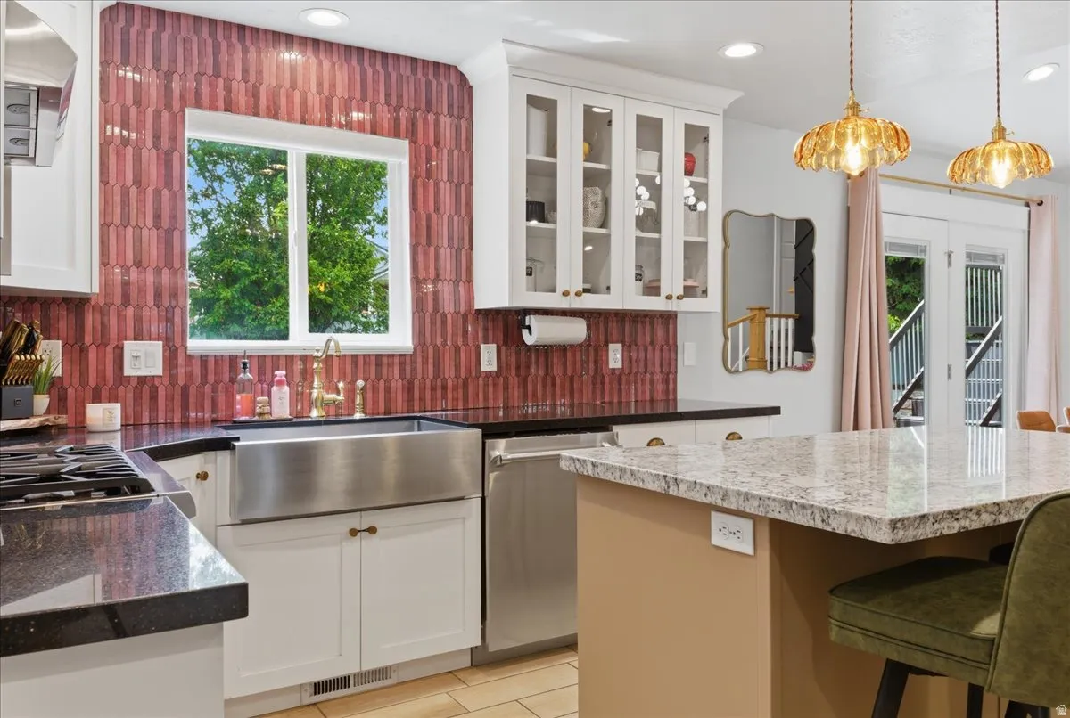 Spacious kitchen featuring a stainless steel appliances, granite countertops, and accented backsplash