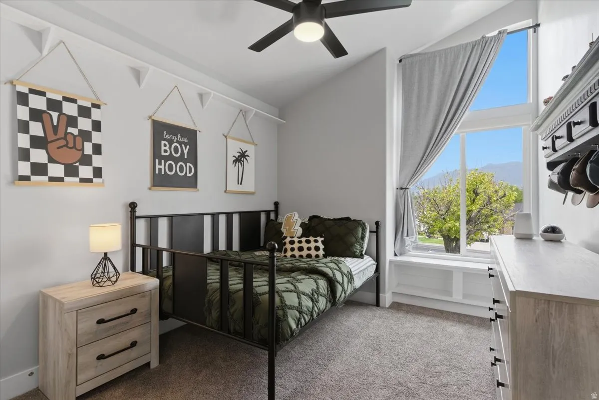 Bedroom with vaulted ceiling with a black ceiling fan