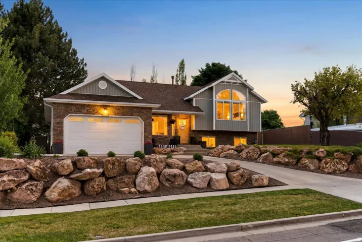 Multi-level residence featuring a two-car garage, rock and hardie board.