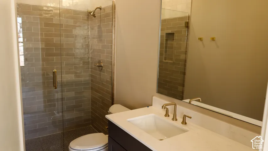 Glass-enclosed shower with subway tile surround, integrated shower niche, and a contrasting penny tile floor