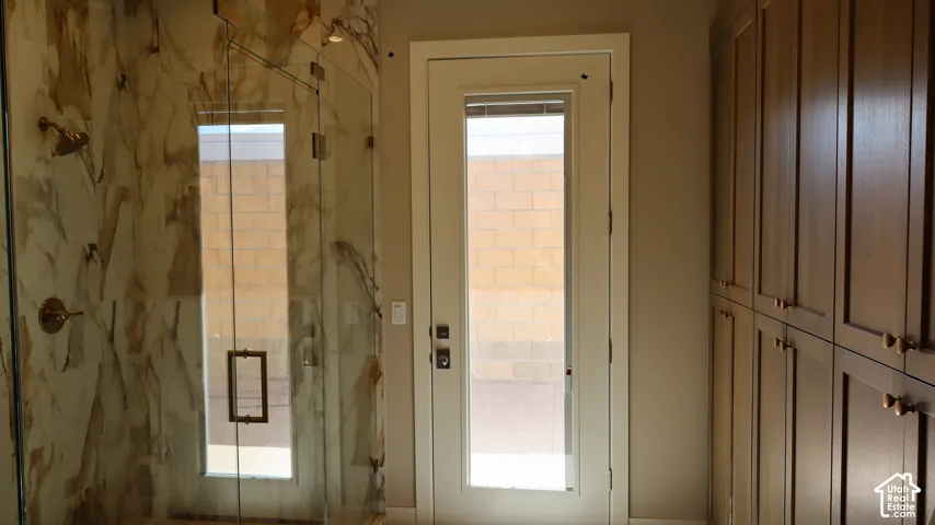 Glass-enclosed shower with a decorative tile surround and bronze-finish fixtures