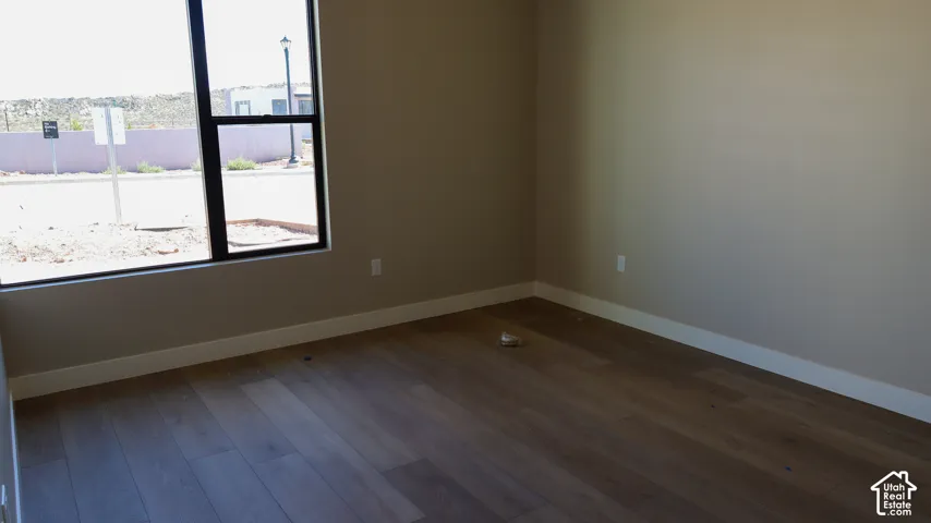 Wood-finish flooring, neutral wall tones, and expansive window