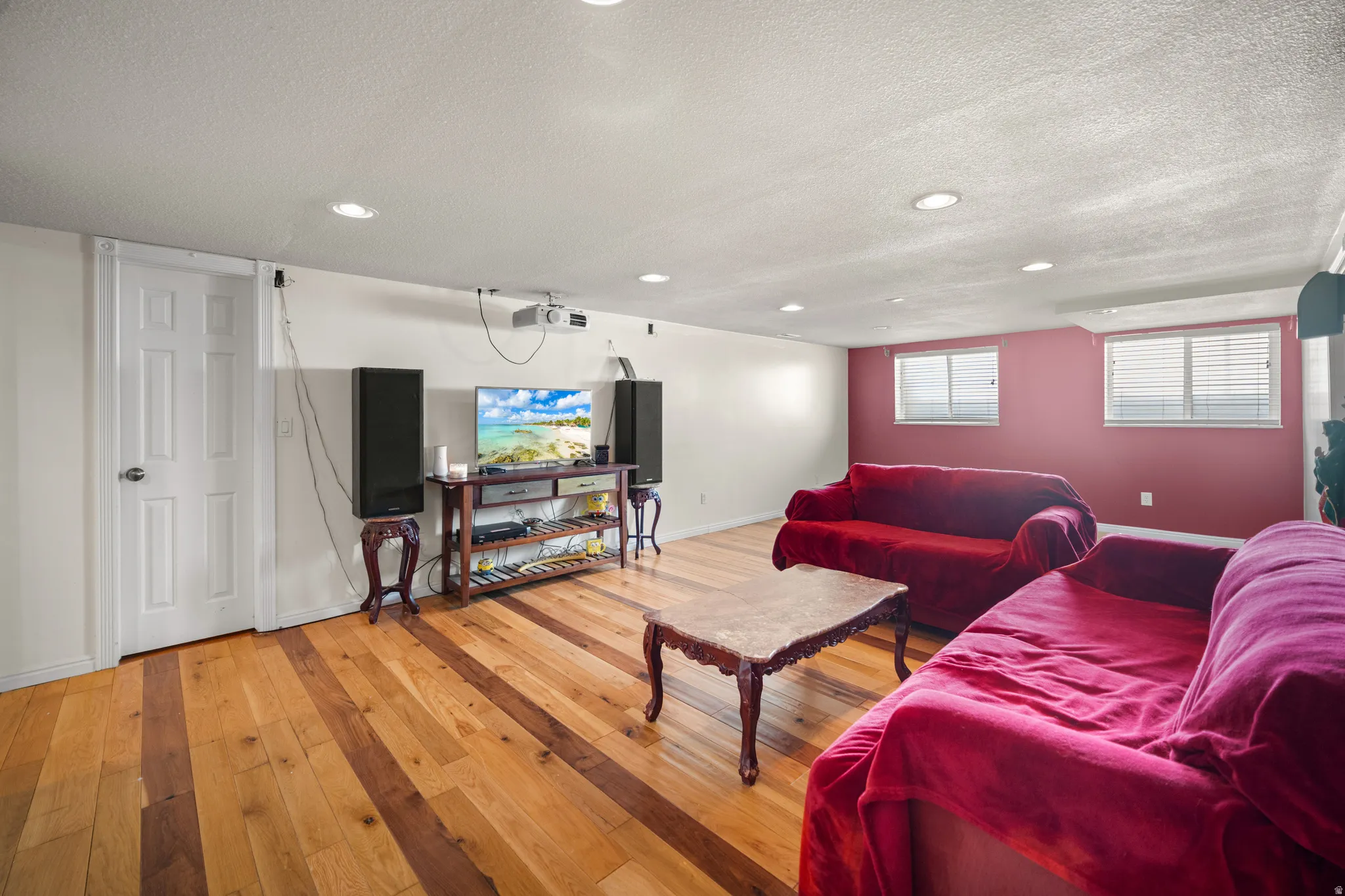 Recreation room featuring wood-finish flooring, recessed lighting, and dual windows with blinds